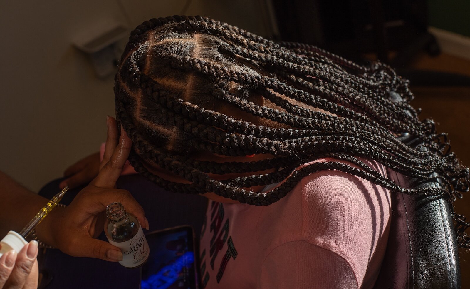 Brianna Cox of Braids by Brie, one of six partner hair professional salons and barbershops that work with Dream of Kalamazoo Foundation, at work braiding hair.