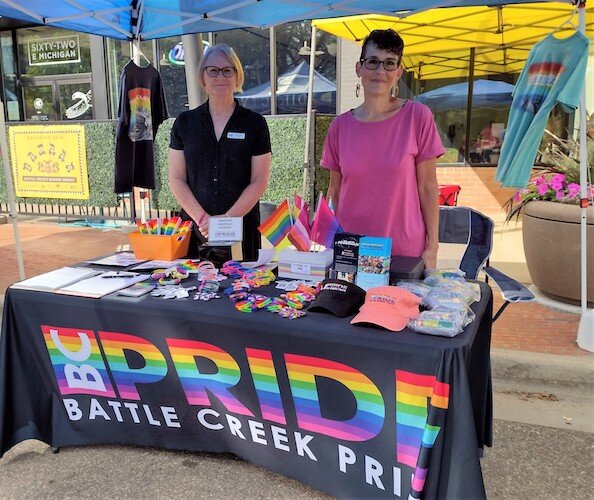 Kim Langridge, left, and Deana Spencer, right, co-presidents of BC Pride, staff a table at a Breaking Bred community event in June in downtown Battle Creek.