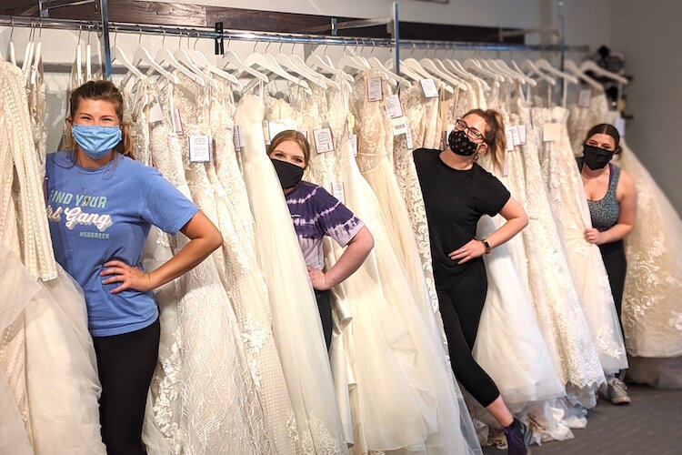 Staff members of Memories Bridal & Evening Wear give the store a deep clean and get set up the day before its reopening. From left: Rachel Hansen, Jodi Isaacson, Kelsey Klug and Mason Bright.