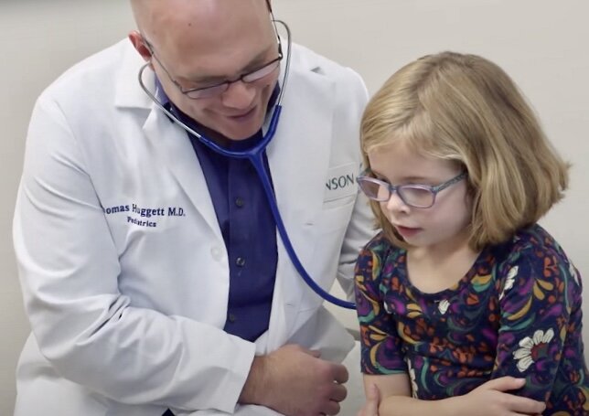 Dr. Thomas Huggett visits with a young patient at Bronson LakeView Family Care in Paw Paw.