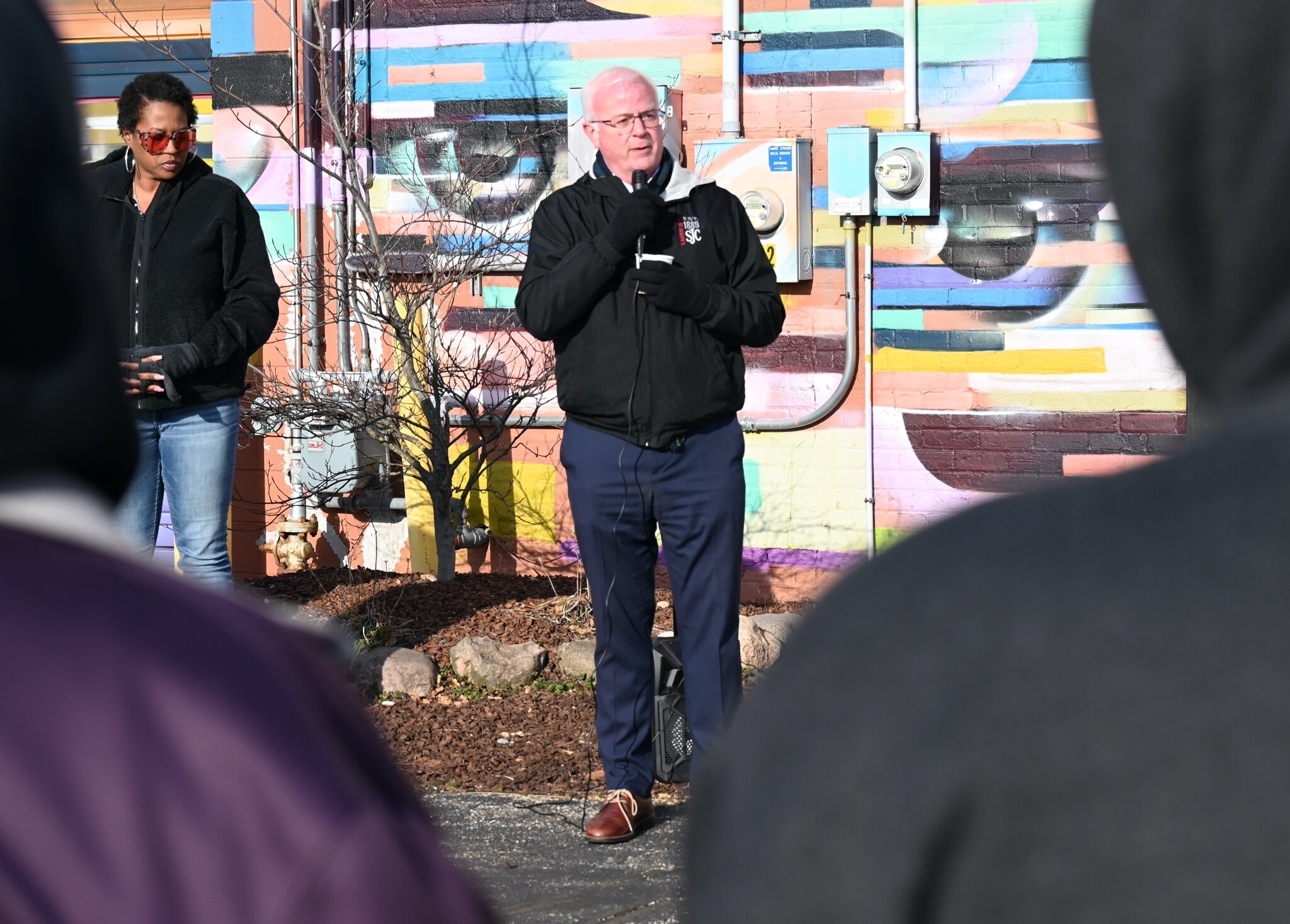 Battle Creek Mayor Mark Behnke speaks and offers a prayer during Sunday’s vigil behind Cafe Rica.
