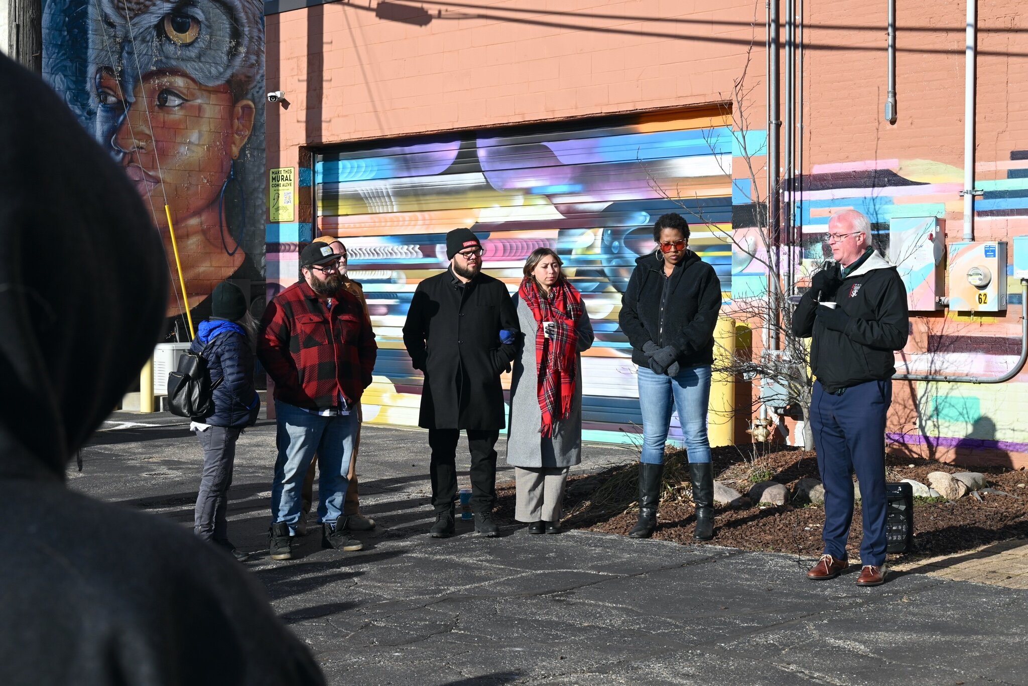 Battle Creek Mayor Mark Behnke speaks and offers a prayer during Sunday’s vigil behind Cafe Rica.
