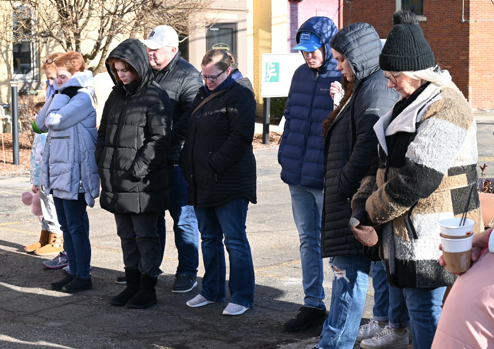 People bow in prayer during the vigil behind Cafe Rica.