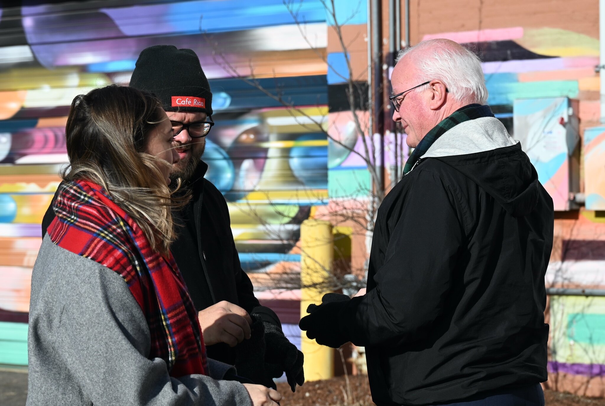 Battle Creek Mayor Mark Behnke talks with Tristan and Michelle Bredehoft priorvto Sunday’s vigil.