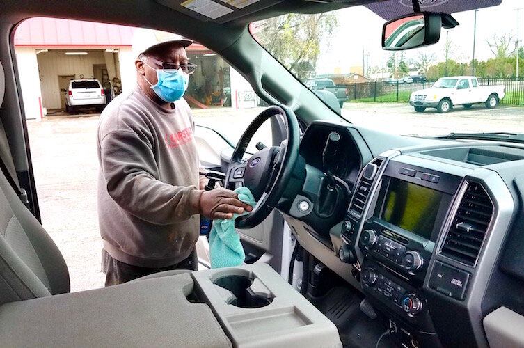 Service technician Robert Head disinfects a vehicle at CARSTAR Kalamazoo.