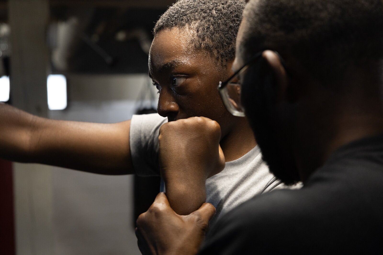 Aimua Osuki, 13, right, trains under the steady gaze of Coach Ja, left. Osuki was 6 when his parents emigrated from Nigeria to Lansing, MI. They moved again to Kalamazoo when he was 8. He is one of the newest arrivals at ChampsDen.
