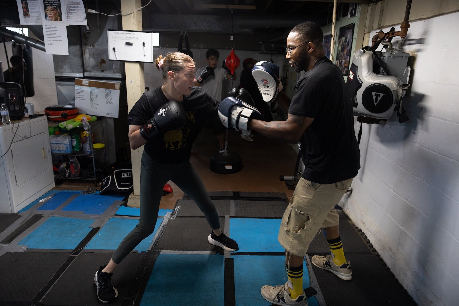 Trisha Eid, 42, (left) practices throwing combinations with Coach Ja on Aug. 11, 2025. Eid moved from Grand Rapids to Kalamazoo a year ago in order to train at ChampsDen.