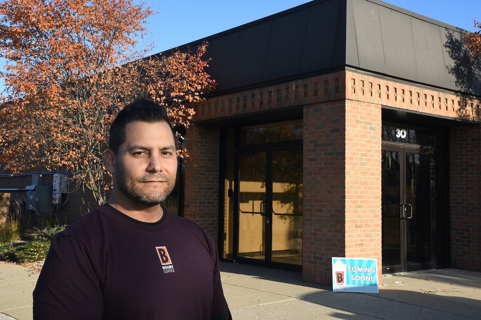 Charles Solano stands in front on a future Biggby Coffee shop he will open next year in the former Chase Bank at the southwest intersection of Hlll Brady and Dickman Roads in the Fort Custer Industrial Park.