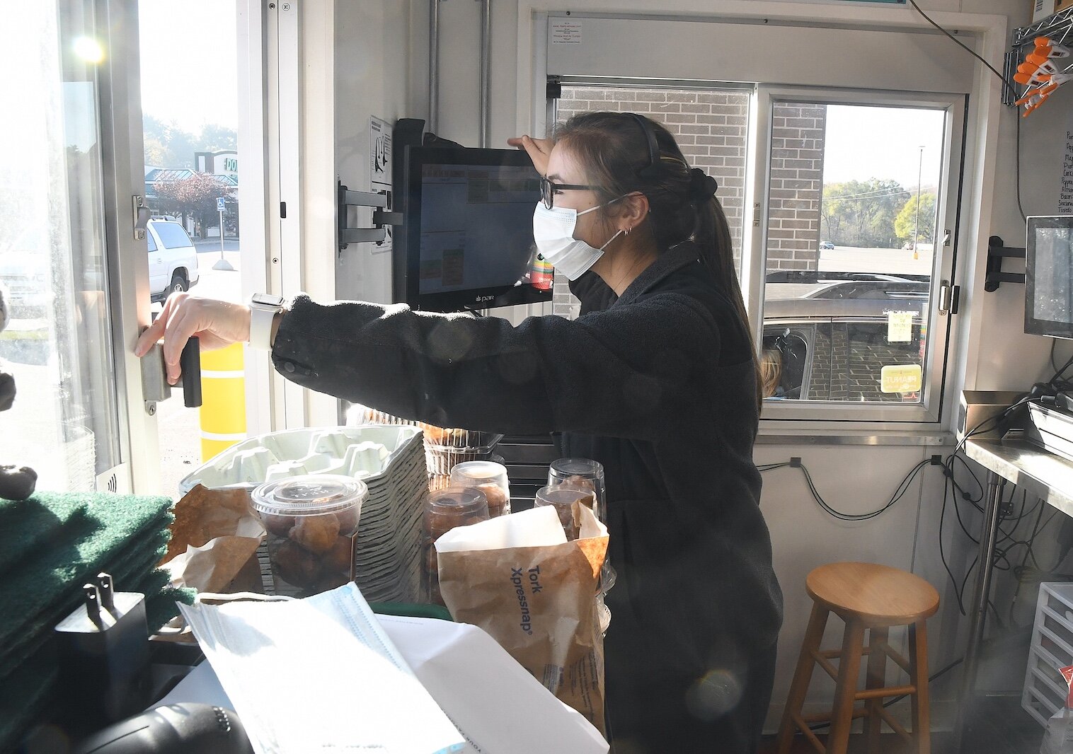 Morgan Gonoe staffs the windows at the newly open drive-up Biggby Coffee shop on West Michigan Avenue in Urbandale.