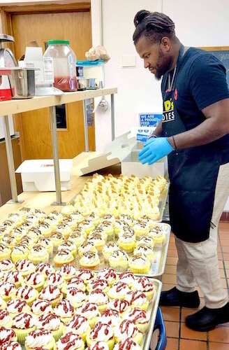 DeMargeo C. White, owner of Huey D’s Goodies, prepares 576 cupcakes recently for Portage dentist Dr. Kenneth W. Grabowski.