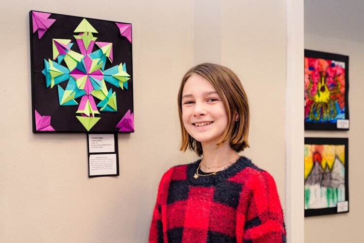 Lilyann Collins from Lakeview Middle School stands by her artwork, Radial Symmetry Origami Composition.