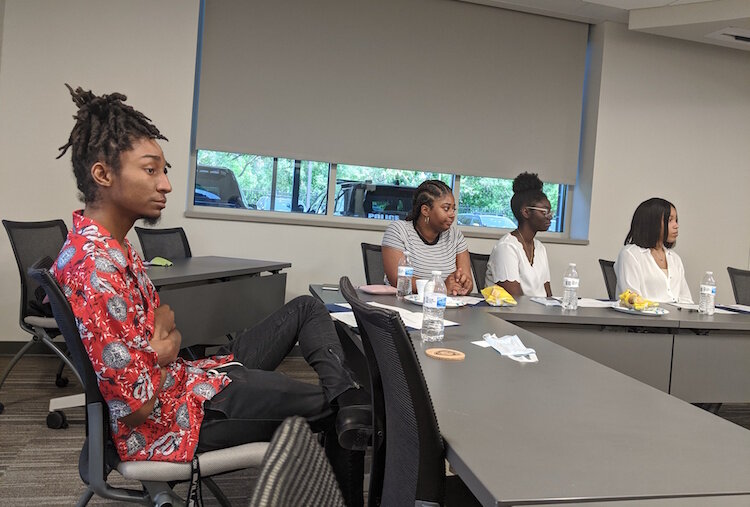 James McGee, a counselor at Northwestern Elementary School, front left, listens to thoughts being shared by those who attended a meeting on Wednesday between members of the Battle Creek Police Department and a group of young adults. 