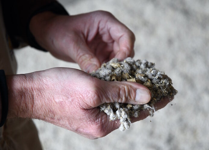 Brad Crandall holds a mix of nutrients, including cotton, soybean hulls and vitamins.