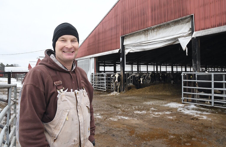 Brad Crandall stands in front of one of the barns at his family’s farm.