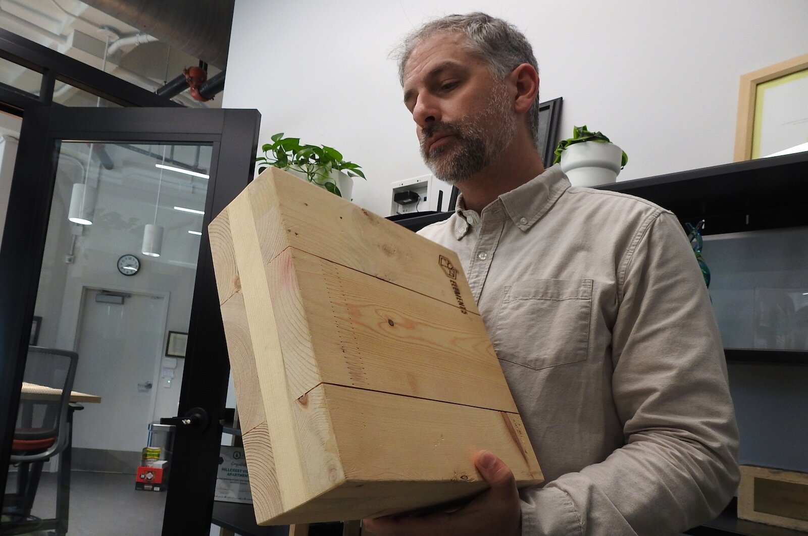Matt Hollander, president of Hollander Development Corp., displays a section of the mass timber his company plans to use to build an all-electric, high-efficiency housing complex in Calhoun County.