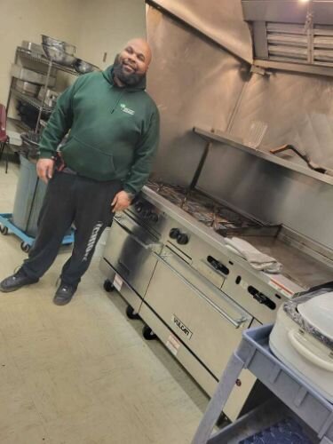 Demetrius Henry, SHARE cook, stands with a new oven purchased through ARPA funds.