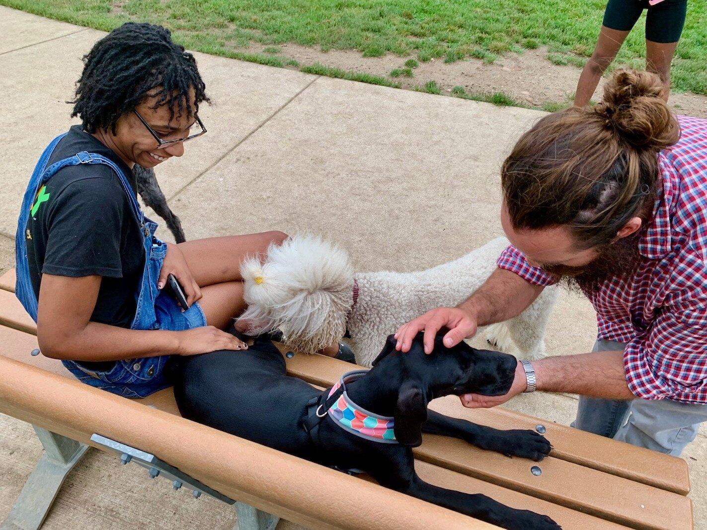 Jana Walker, left, and Ben Stanley greet one another’s dogs on a recent Thursday at Fairmount Dog Park.