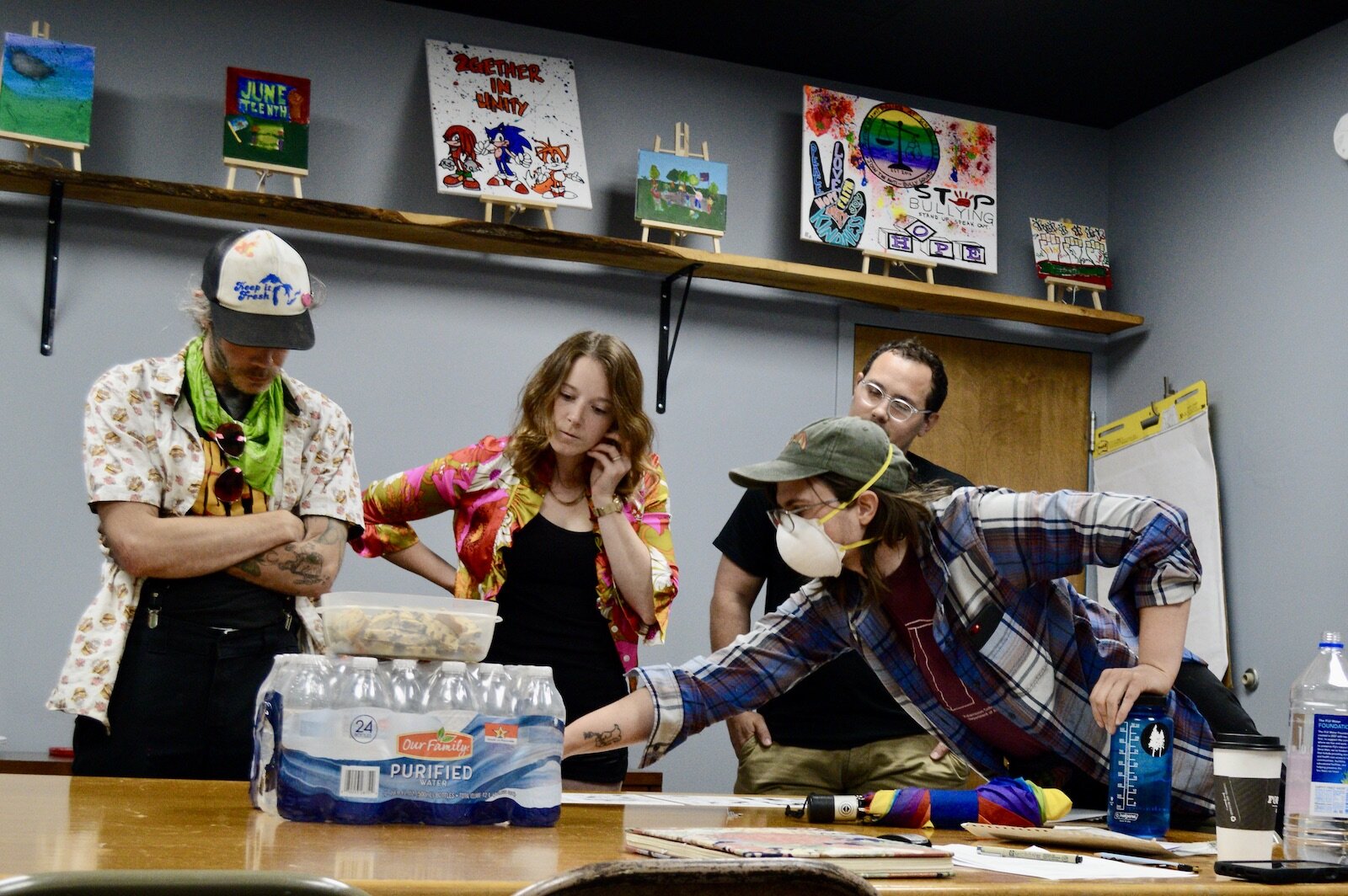 Daniel Staggs, Ellen Nelson, Qynce Chumley and C. J. Kins look over panels of Chumley's comic.