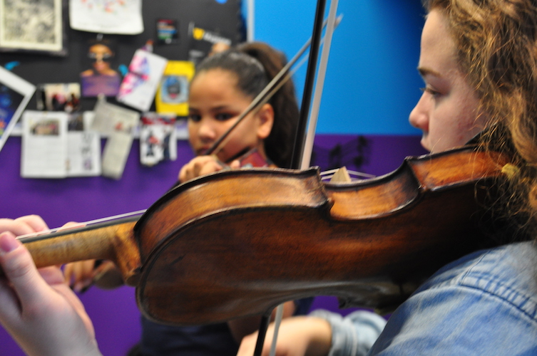 Samira, a 4th grade Kalamazoo Public School student, plays a piece for her teacher, Alexis Terrian, a Western Michigan University sophomore.