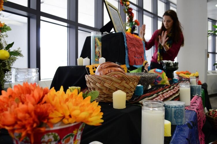 Images of Catrinas, sugar skulls, baskets of fruit on display.