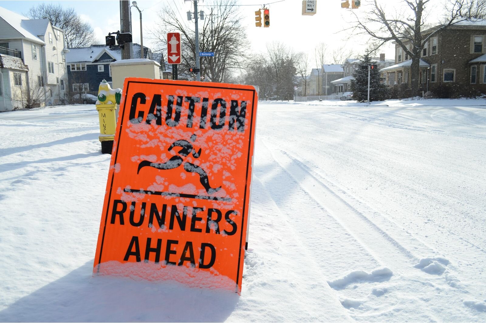 A sign warns drivers to watch out runners getting prepared for the upcoming Kalamazoo Marathon.