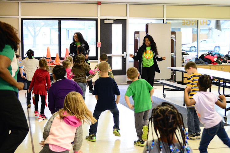 From left, Operation Fit coordinators Mariama Wurie, Tamera Gibbs and Emirrora Austin lead LaMora Park kindergarten students in a ”Brain Break.” Photo by Mark Wedel