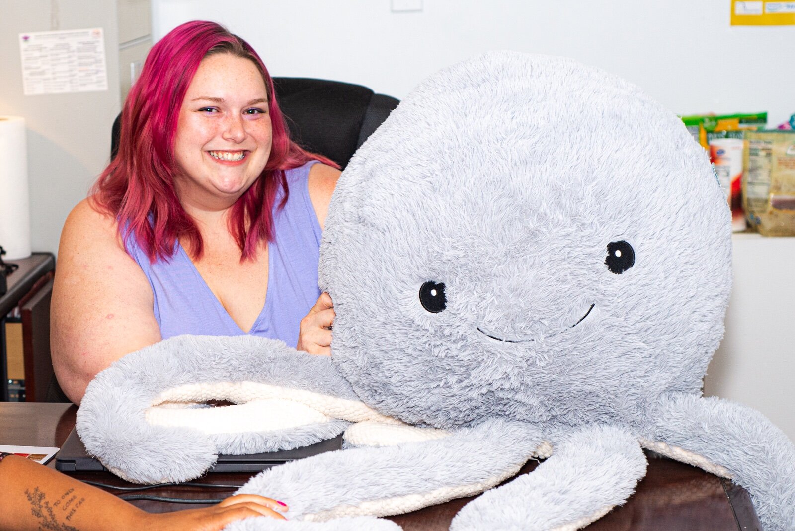 Tabi and Earnest the giant stuffed octopus in her office. She says anyone can come in, sit on a soft couch, and hug him if they need a moment. Photo by Taylor Scamehorn