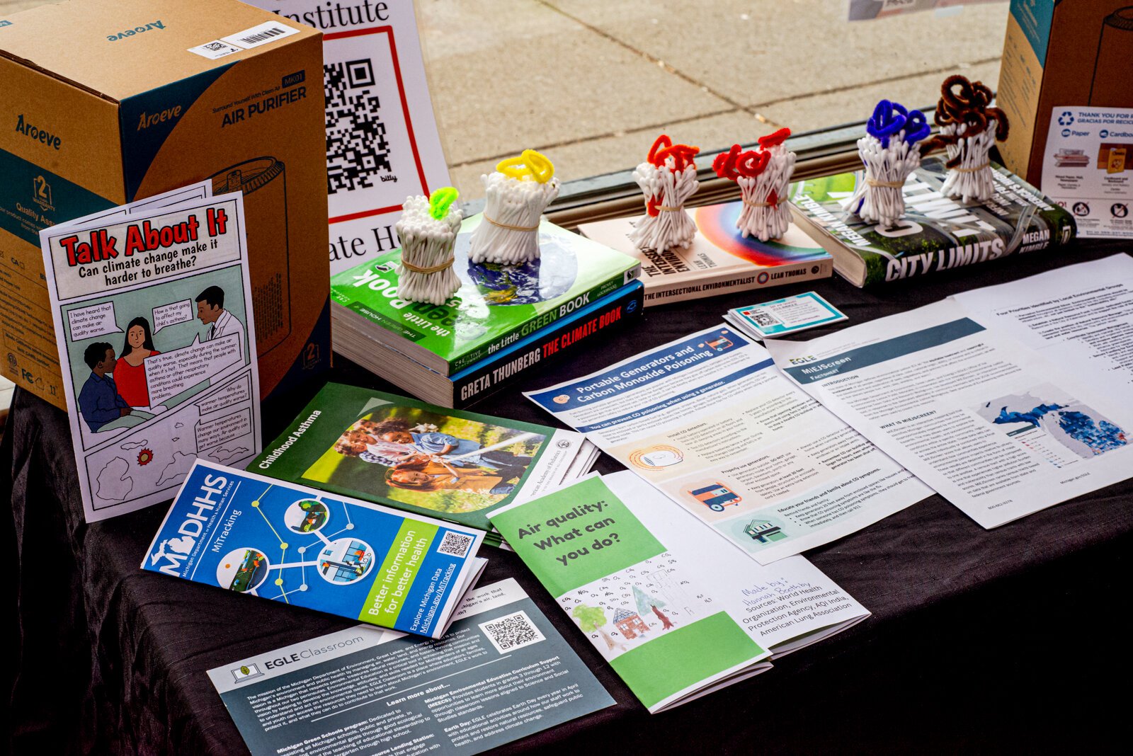 Entrypoint table with free air filters and literature on air quality safety, impacts of pollution on human health and the environment.