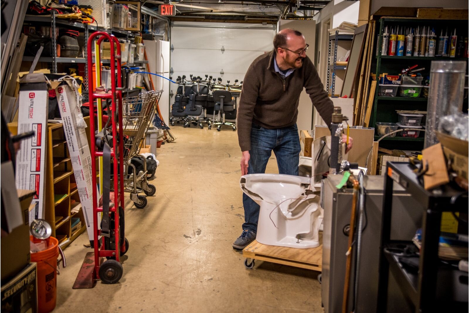 Executive Director Chris Praedel shows off a half-toilet, one of the props used in Community Homeworks' DIY home repair classes.