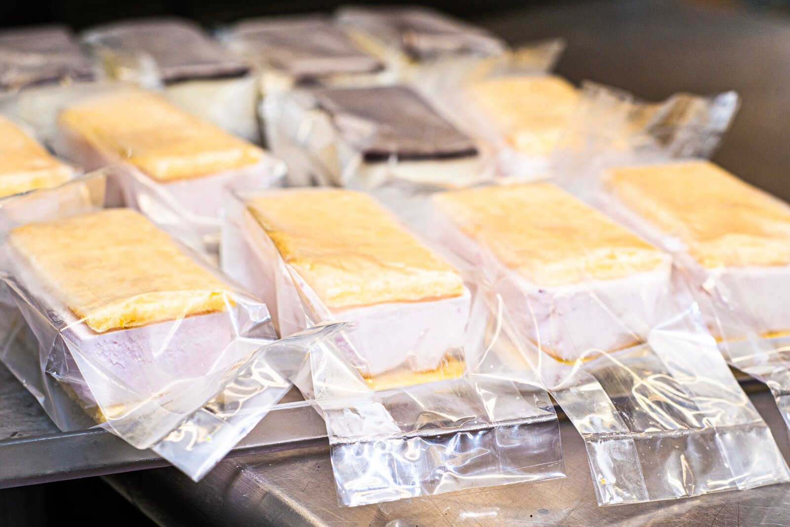 Ken Quayle displays some Strawberry Buttermilk ice cream sandwiches constructed with Lemon Sugar Cookies made special by Sarkozy’s Bakery. In  the background are coffee ice cream sandwiches using Higher Grounds coffee (another partner).