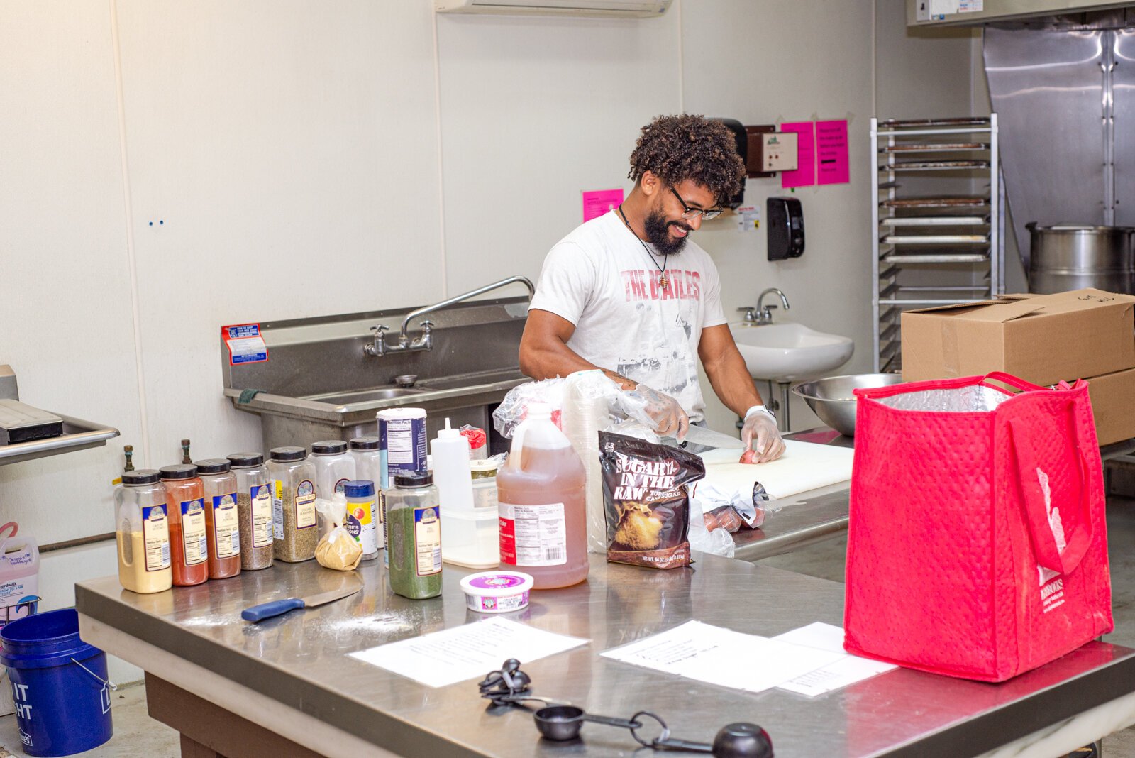 Derick Waters and Nina Martinez prepare garlic parm bites in the mixer and are slicing red potatoes for potato salad.