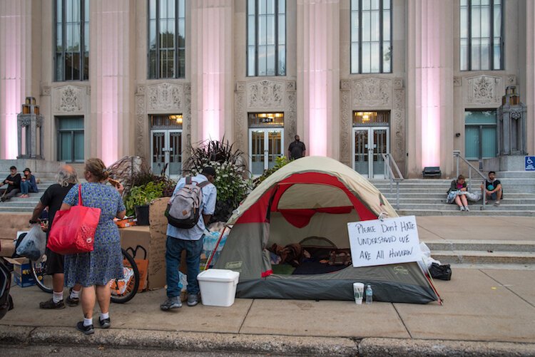 Homeless indviduals asked people to stop and talk to them on city hall steps during the 2018 encampment downtown.