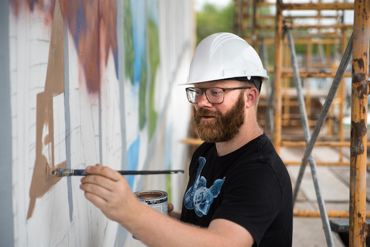 Patrick Hershberger at work on a new mural for the Edison neighborhood. Photo by Fran Dwight