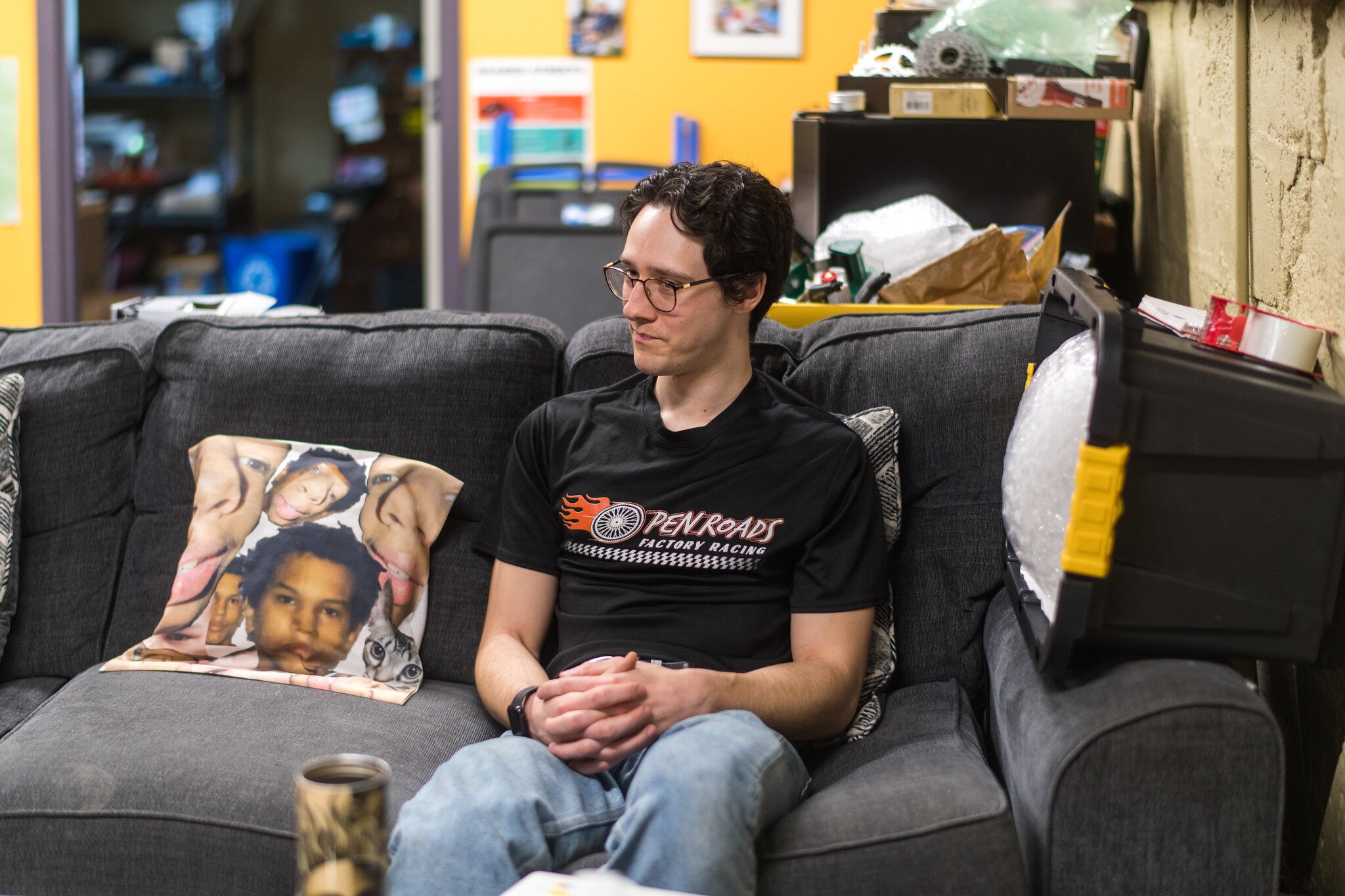 Ian Smith, Open Roads' Program Manager, sits next to a pillow that honors Devin, one of the organization's star workers.