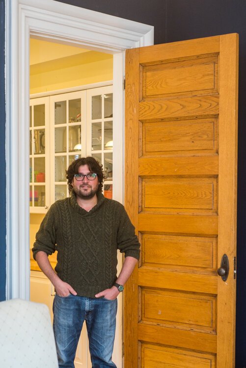 Nathan Dannison stands in the doorway of his historic Vine home, where ceilings, both lower and upper, and doorways, are very tall.