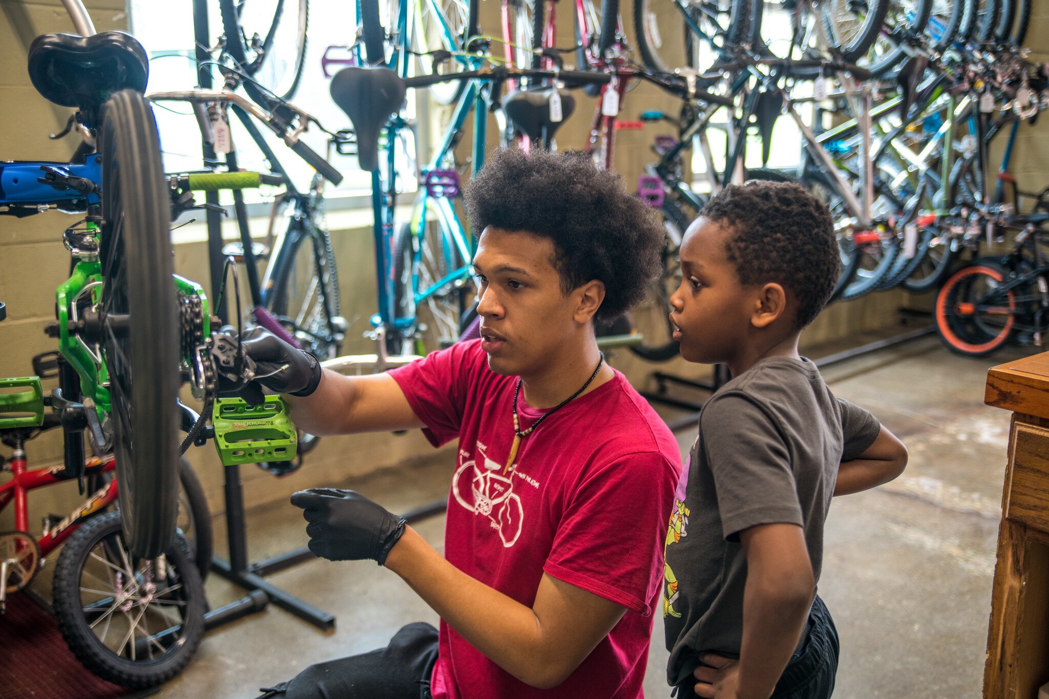 Devin at Open Roads helps a young bicyclist.