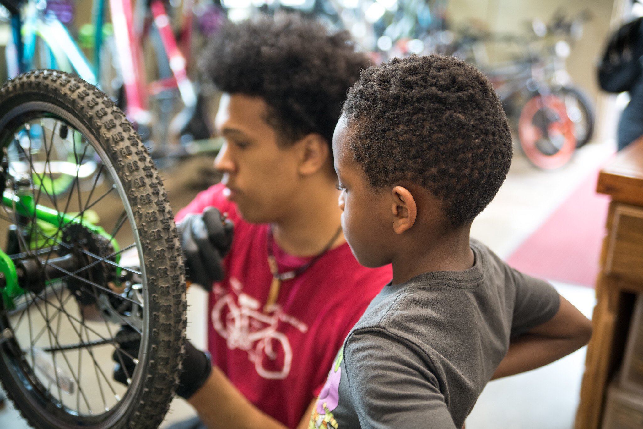 Devin at Open Roads helps a young bicyclist.