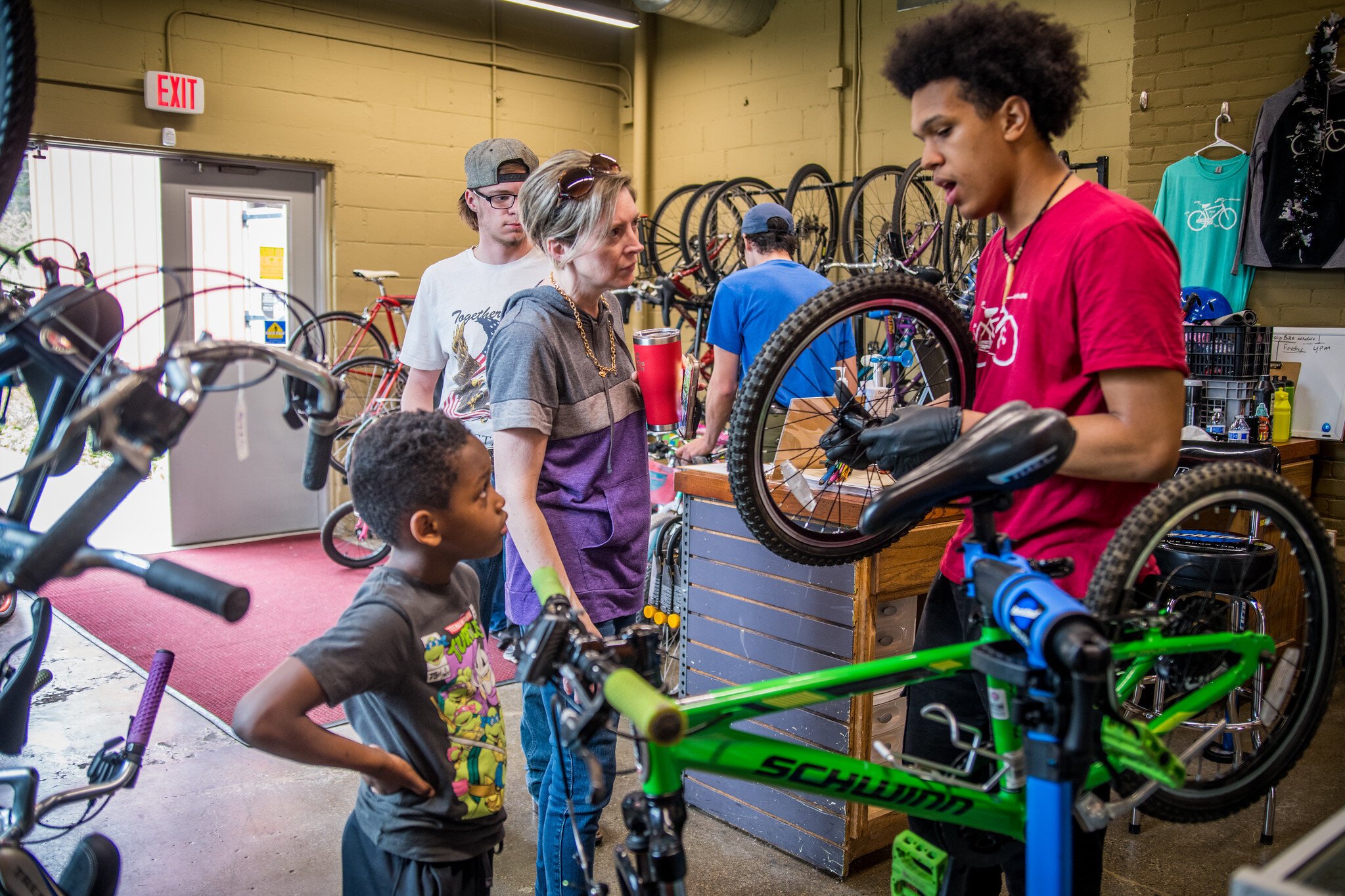 Devin at Open Roads helps a young bicyclist.