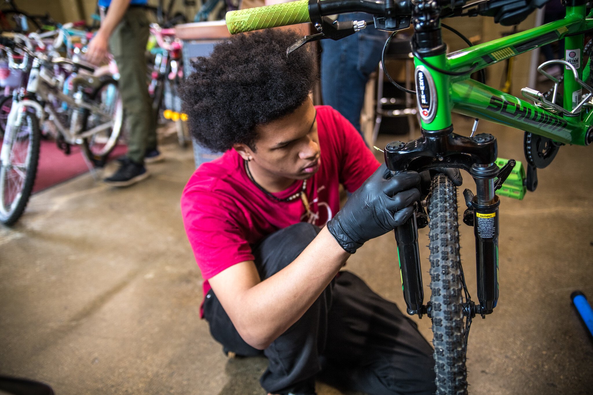 Devin at Open Roads helps a young bicyclist.