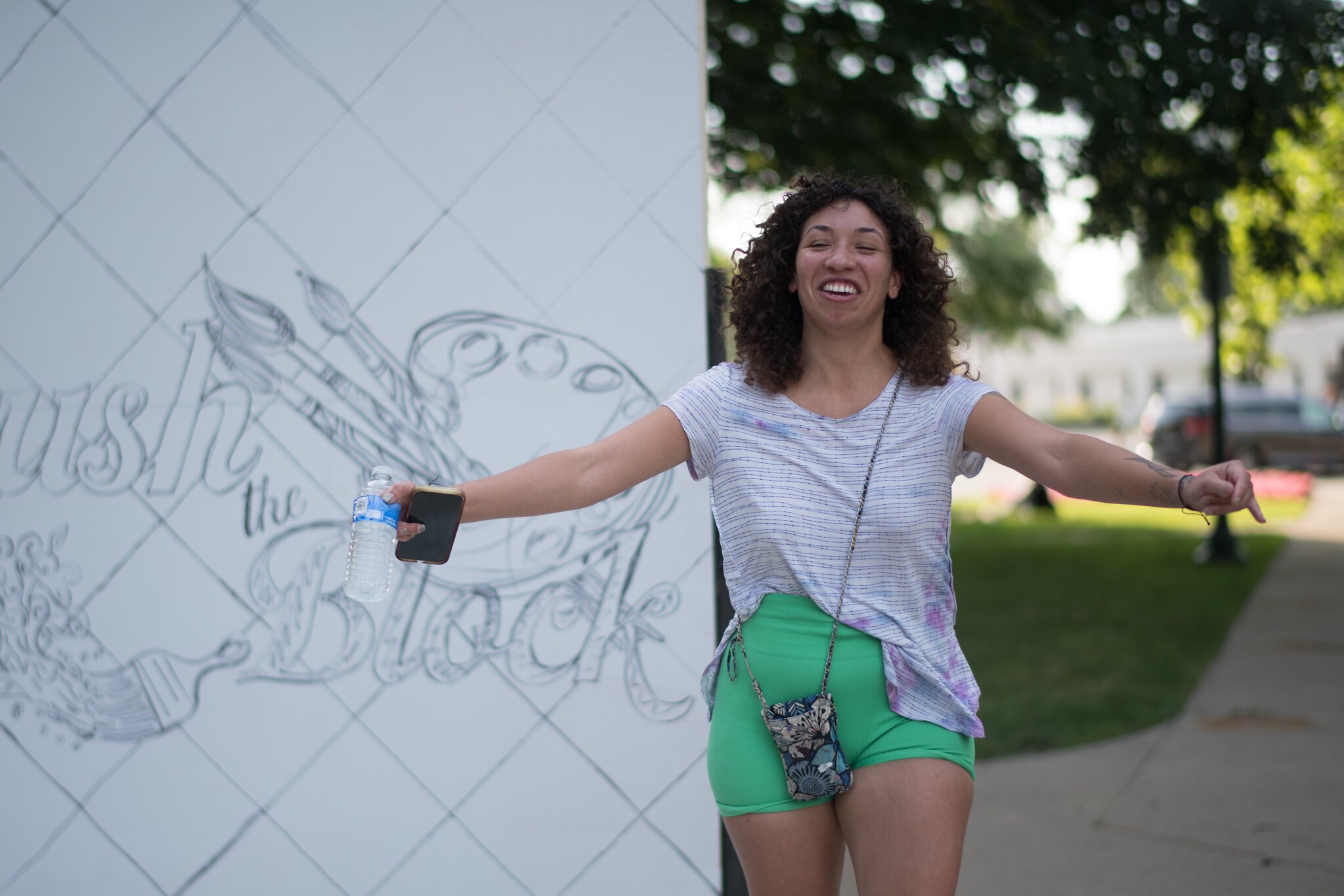Artist Maya James celebrates having been chosen to paint a mural on the side of the Kalamazoo Transit Building.