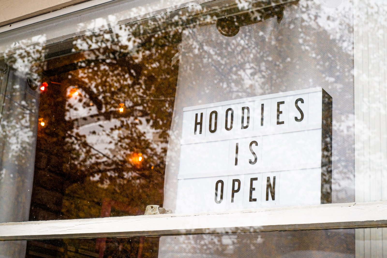 The sign in the window of Hoodies.