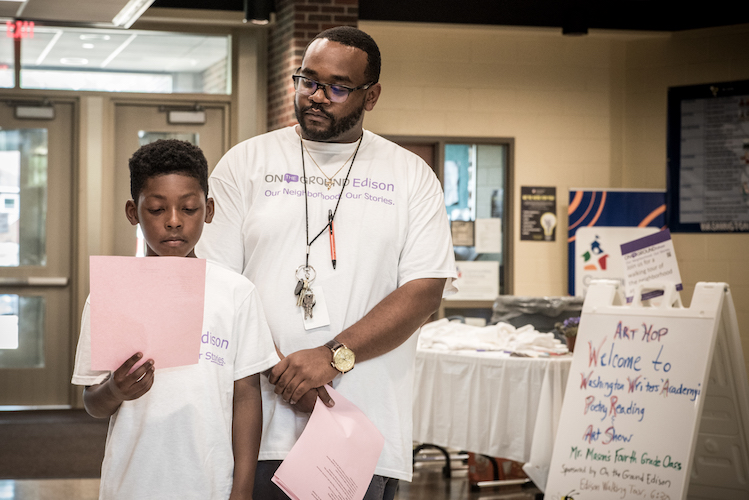 Jayden Brigham reads his poem along with his teacher Mr. Mason at Art Hop.