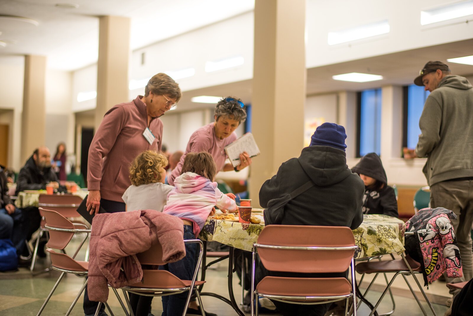 Donna Schonveld and Wendy King with visitors to the Wednesday evening dinner at First Presbyterian Church.