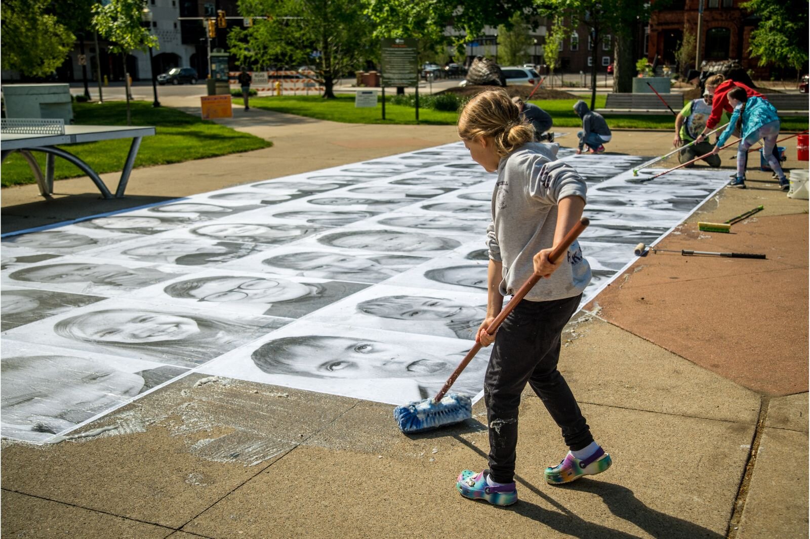 Most students won't see their portraits until Friday's All-District Art Fair, but a few helped affix the portraits to the sidewalks.