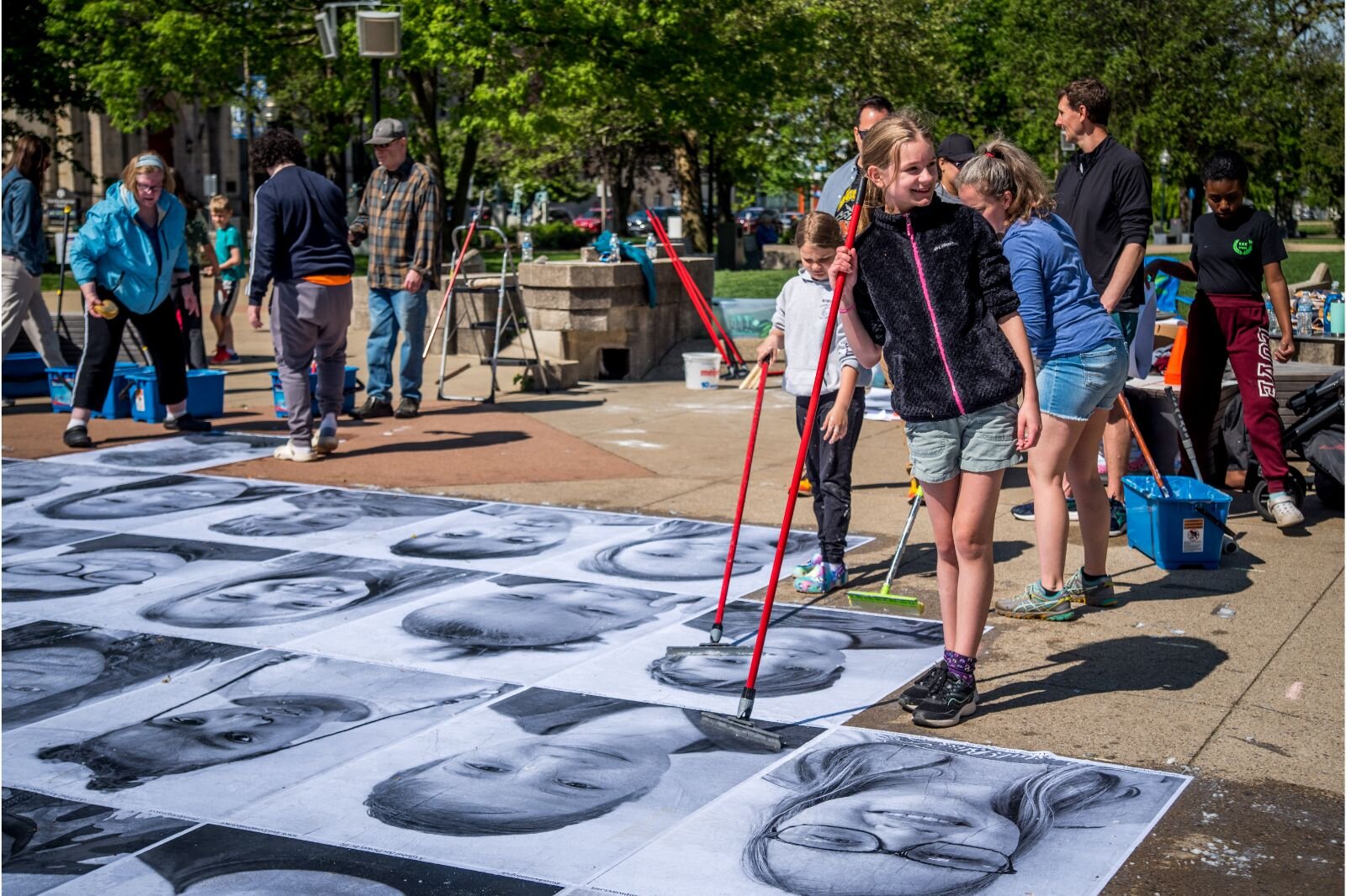 Over the course of a week, parents, students, and teachers volunteered to paste 4 1/2  X 3 feet black and white student portraits on the sidewalks of Bronson Park in preparation of the All-District Art Fair on Friday, May 19. 