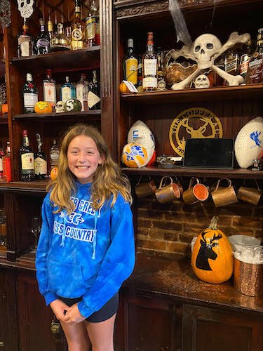  Ella Laupp poses with a pumpkin that she painted a deer on. The pumpkin was on display at the Copper Athletic Club in Marshall. She’s also has painted pumpkins with the logos of college and professional football teams for its customers.