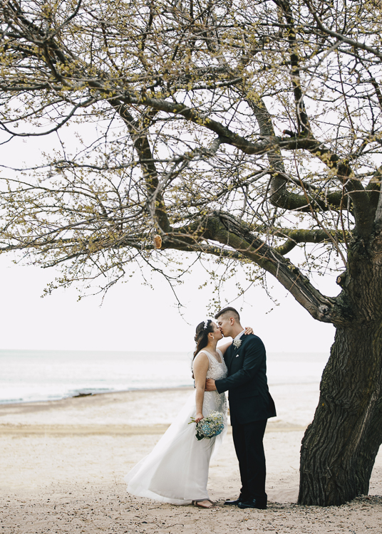 Setting accentuates the subject, particularly here with a newly-married couple beneath a tree in bud. 