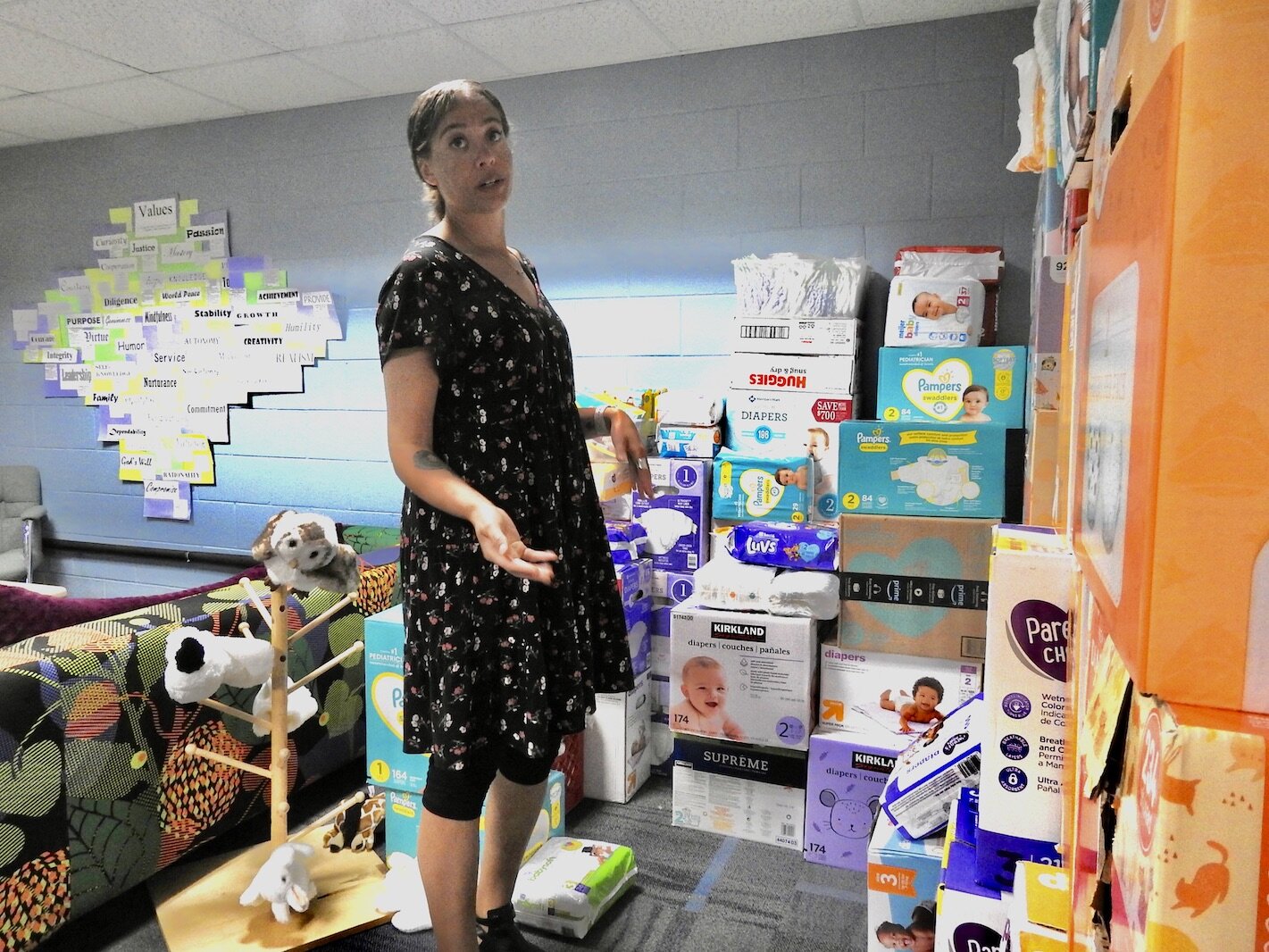 Victoria Orbe, directora de servicios infantiles de Community Healing Centers en Kalamazoo, se encuentra en mayo cerca de los pañales recogidos para su distribución a los padres que luchan para apoyar a los niños en riesgo de luchas de salud mental. 
