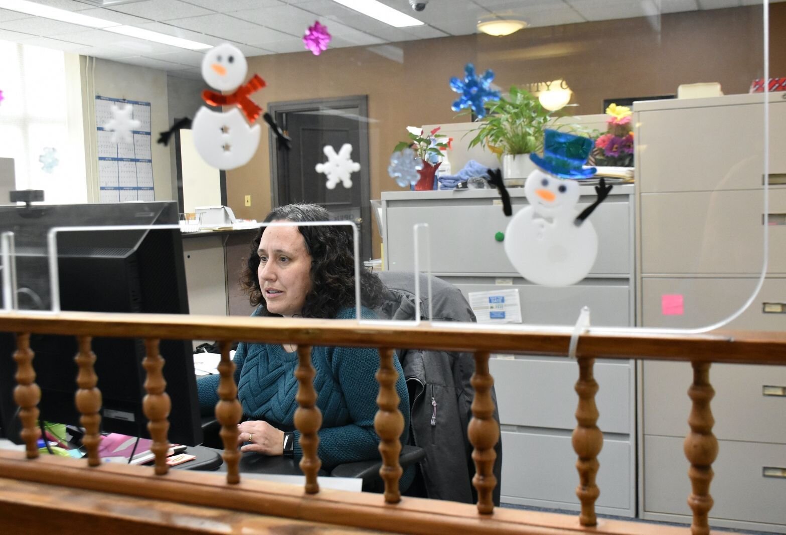 Lisa Silkworth, Records/Election clerk for the City of Battle Creek, works behind plexiglass at Battle Creek’s City Hall.