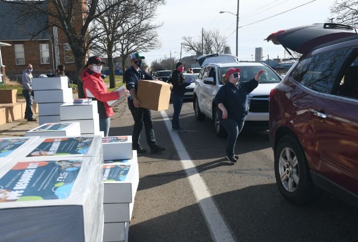 Volunteers hand out boxes of food, personal protection supplies outside New Level Ministries on West Van Buren Street on Saturday morning.